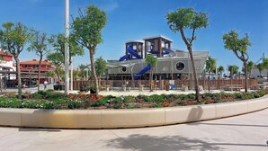 A modern building with a blue slide and a covered seating area.