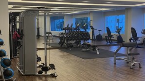 Ein Fitnessstudio mit unterschiedlichen Trainingsgeräten, darunter Laufbänder, Ergometer und Kraftgeräte.