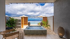 Un espace piscine extérieur moderne avec vue sur la plage, agrémenté de mobilier en bois et de plantes.