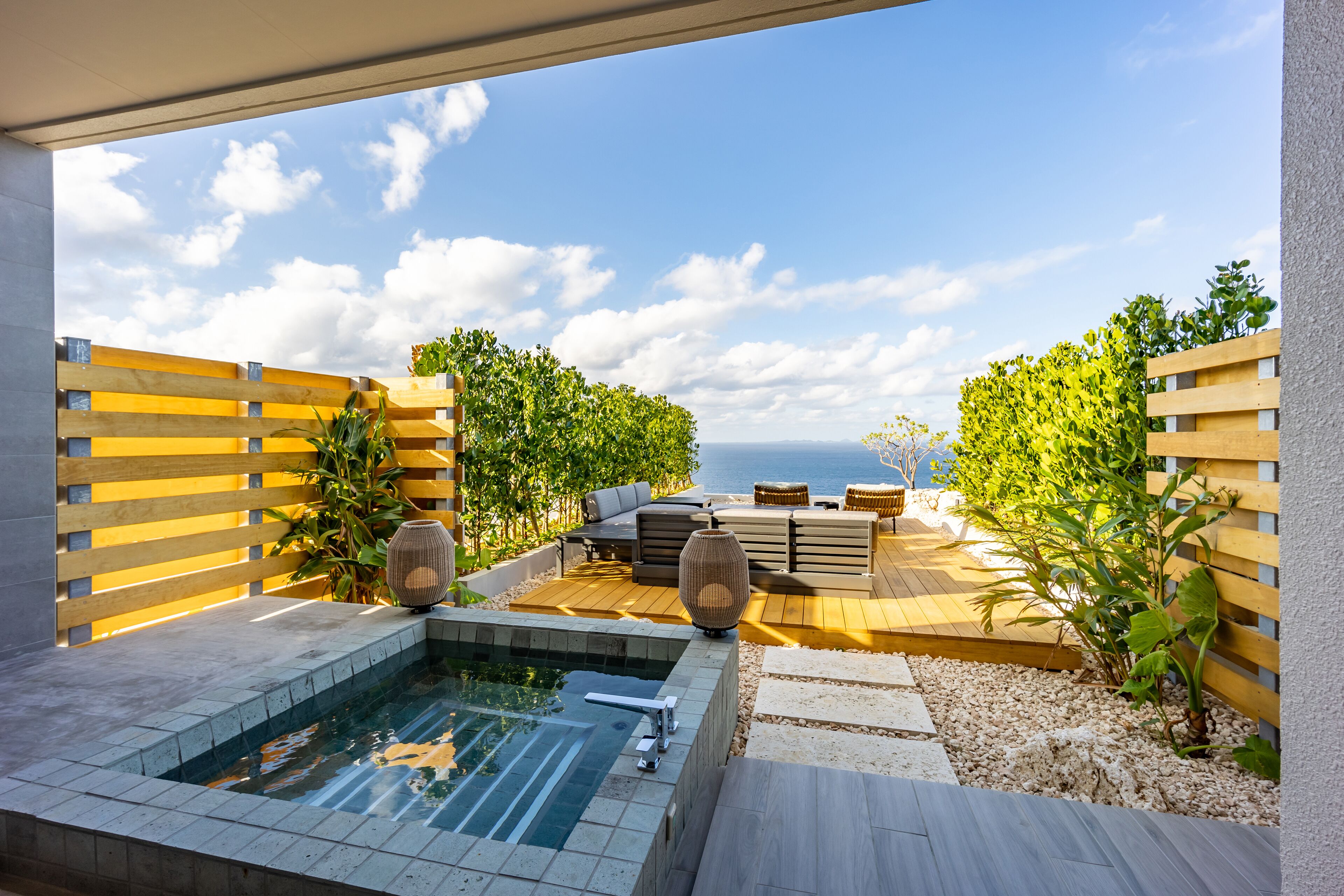 A rooftop terrace with a hot tub, outdoor seating, and a view of the sea.
