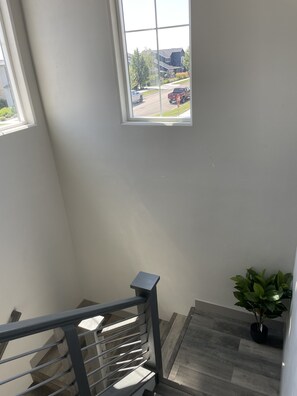 Staircase leads to a spacious upper floor with a view of the surrounding neighborhood.