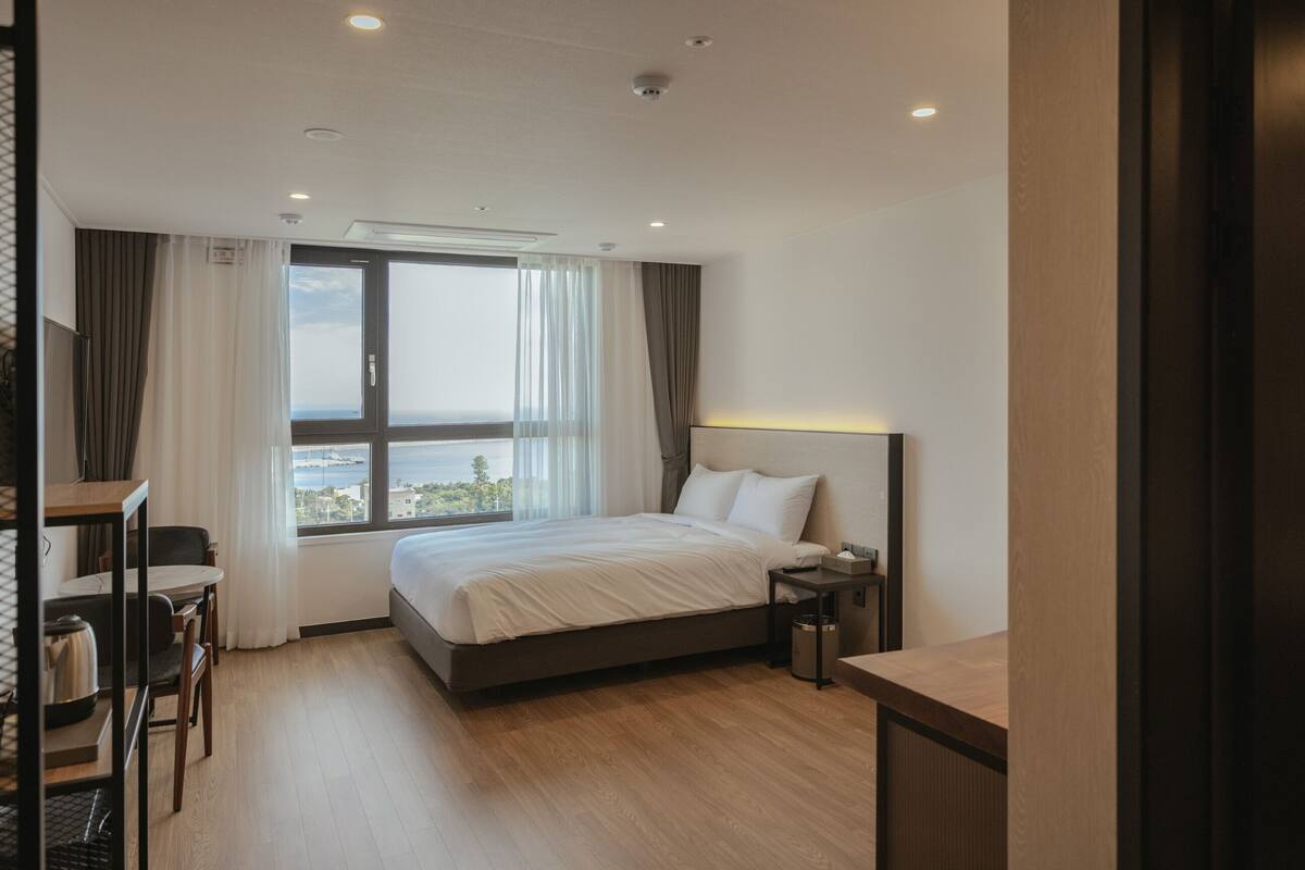 Une chambre d’hôtel moderne avec un grand lit, un bureau et une vue sur la ville.