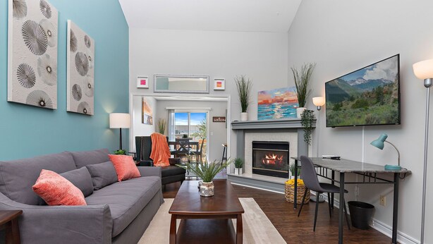 A modern living room with a grey sofa, a wooden coffee table, and a fireplace.