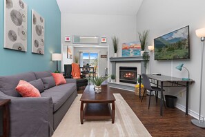 A modern living room with a grey sofa, a wooden coffee table, and a fireplace. - ⭐️ Luxe Paradise ⭐️ 3 King Beds ✅ Fast Wifi ✅ Free Parking (Raymore)