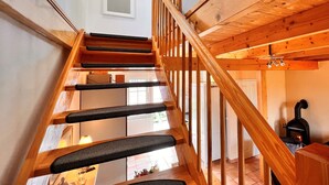 Una escalera de madera con peldaños acolchados negros que conducen a un segundo piso.