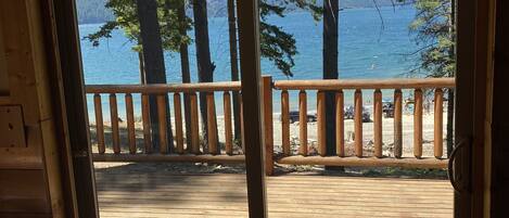 Una terraza de madera con vista a un lago y árboles.