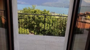 Un balcón con vistas a montañas y un lago.