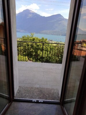 A balcony with a view of mountains and a lake.