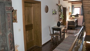 A traditional interior with wooden doors, a dining area with a table and chairs, and a staircase leading to an upper level. - VACATION AT THE FARM HIDEAWAY IN THE ALPS (Stuhlfelden)