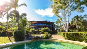 A modern building with a pool surrounded by tropical vegetation. - Anchorage 14, Anchorage 14 on Hamilton Island (Hamilton Island)