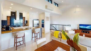 A modern apartment with a kitchen, dining area, and living room. - Anchorage 14, Anchorage 14 on Hamilton Island (Hamilton Island)