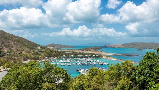 A marina with boats docked, surrounded by lush greenery and hills. - Anchorage 14, Anchorage 14 on Hamilton Island (Hamilton Island)