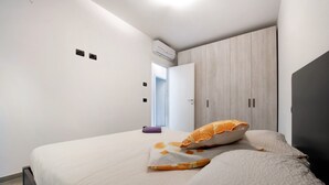 A bedroom with a bed, a wardrobe, and an air conditioning unit. - New Apartment Casa Andrea with Lake View, Terrace and On-Site Free Parking (TREZZONE)