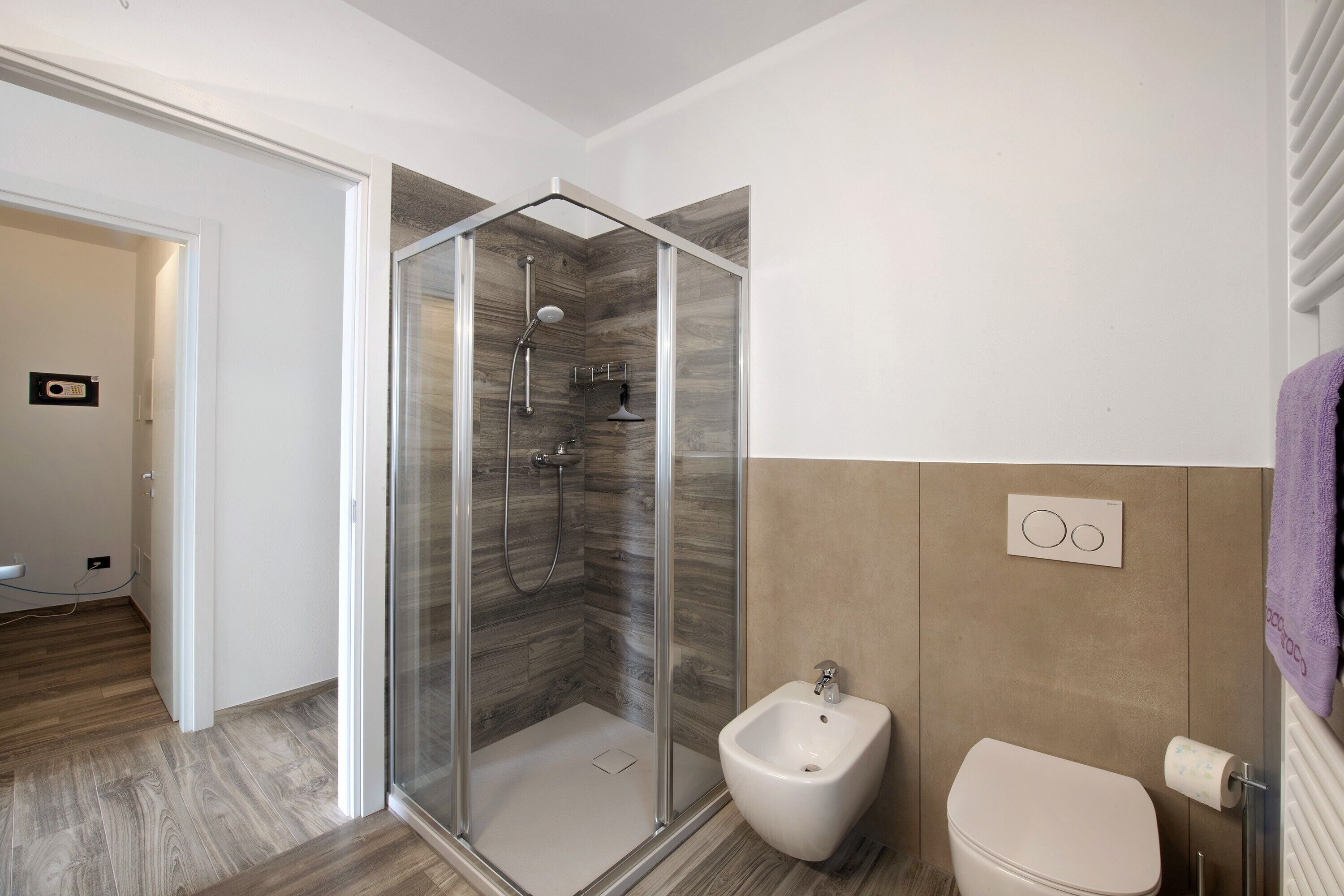 Une salle de bain moderne avec une douche à parois de verre, un bidet et des toilettes.