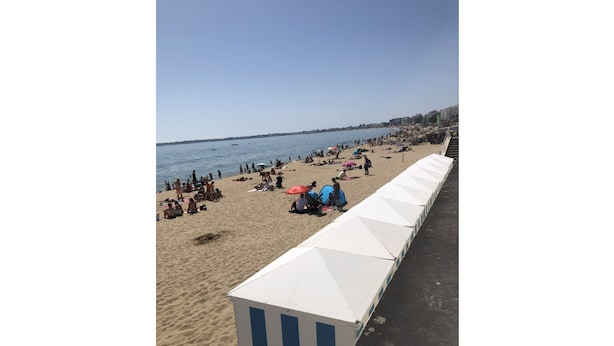 A beach with people sunbathing and swimming, a row of white tents, and a clear sky. - Spacious accommodation, private garden 1200m from Léa baule beach (Guerande (Beslon))