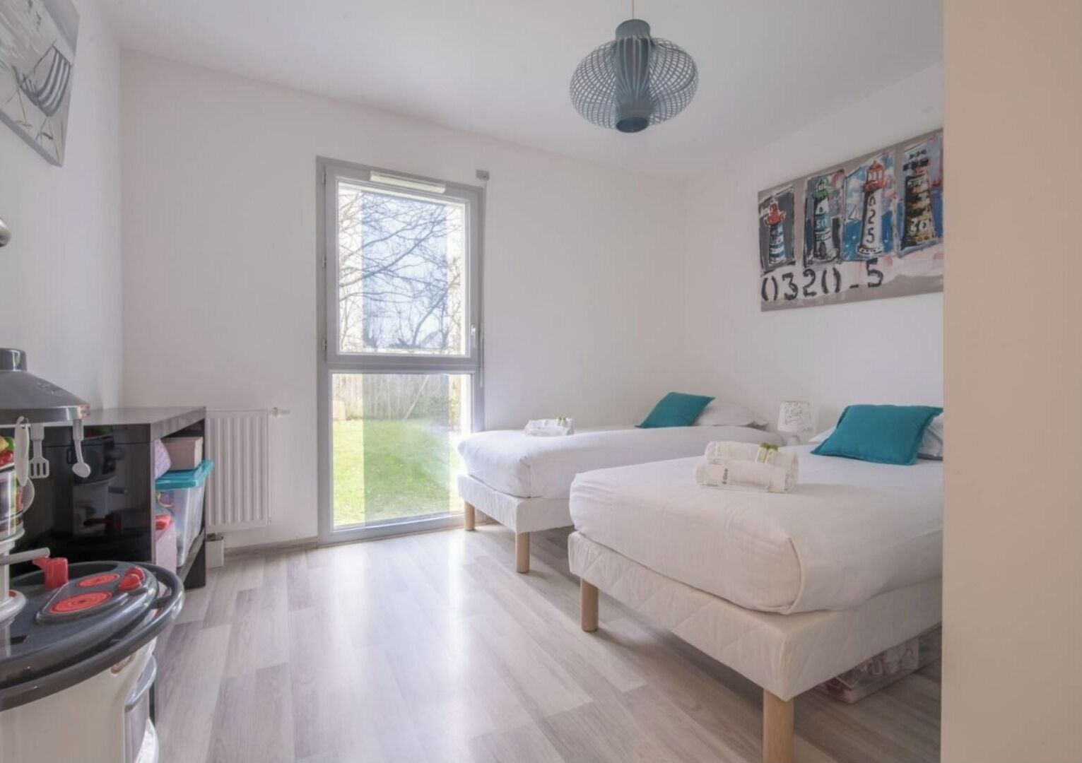Ein modernes Schlafzimmer mit zwei Betten, einer Küchenzeile und einem großen Fenster.