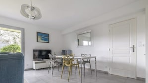 A modern living room with a dining area, a television, and a large window. - Spacious accommodation, private garden 1200m from Léa baule beach (Guerande (Beslon))