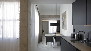 A modern kitchen with a central island, a built-in oven, and a stainless steel sink. - Mon Suites Fetén (Valencia)