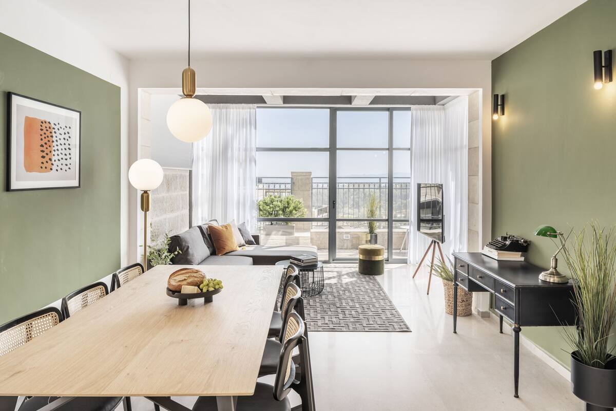 A modern living space with a dining area, kitchen, and balcony.