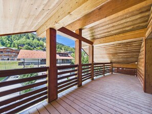 Une terrasse en bois offrant une vue sur une région montagneuse.