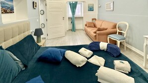 A bedroom with a bed, a sofa, a chair, and a window. - Beautiful Big Studio for 4 people in the Heart of Naples 1B (Napoli)