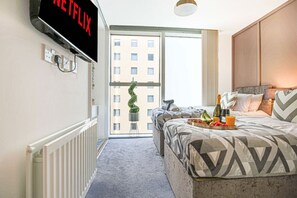 1 habitación, escritorio, tabla de planchar con plancha y cuna de viaje 