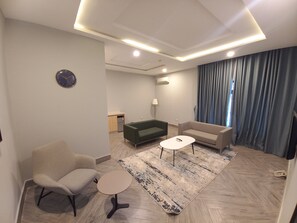 Suite Business | Zona de estar | Smart TV de 65 pulgadas con canales por cable, una televisión