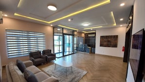 A modern hotel lobby with a sofa, chairs, a coffee table, and artwork on the walls. - SOLACE SUITS & HOMES (Abuja)