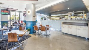 Un restaurant modern amb zona de dinar, cuina i un senyal de teatre.