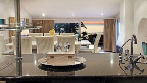 A modern bathroom with a large mirror, a black countertop, and a sink with a faucet. - Ocean Views, Pool, Sleeps 6, Camps Bay - Rontree (Cape Town)