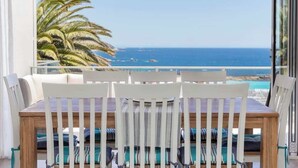 Un balcón con vista al mar y palmeras.