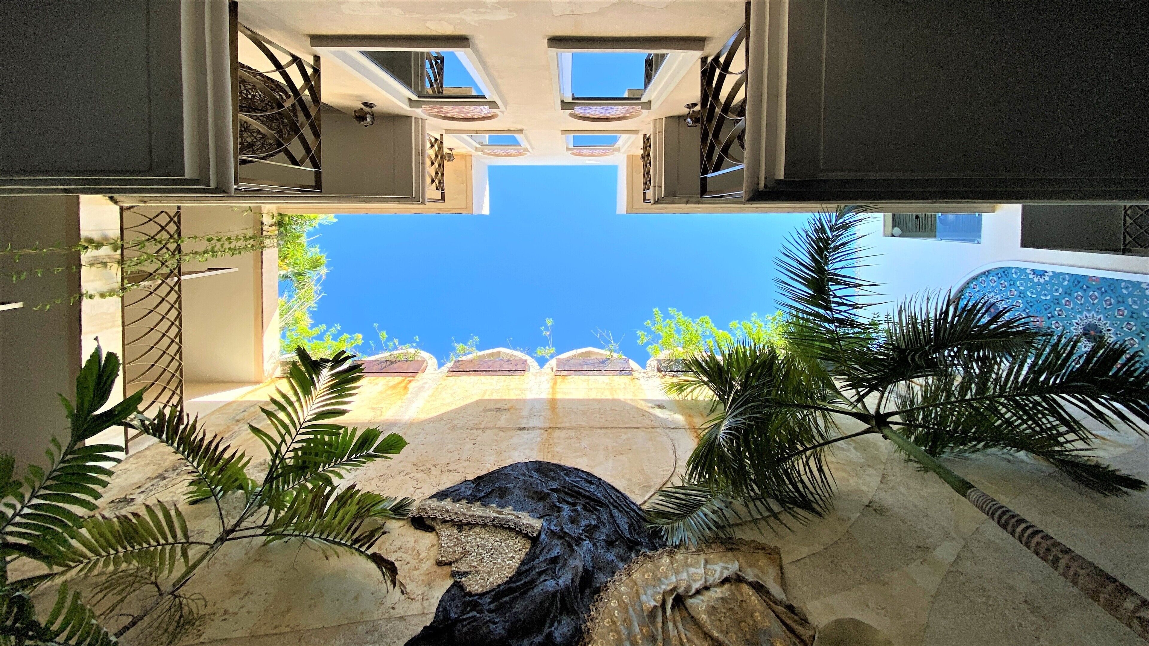 A modern interior with a central open space, a ceiling with skylights, and a view of the sky.