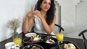 A person seated at a table with breakfast items including toast, eggs, and a glass of orange juice. - Layla Tulum - Adults Only (Tulum)