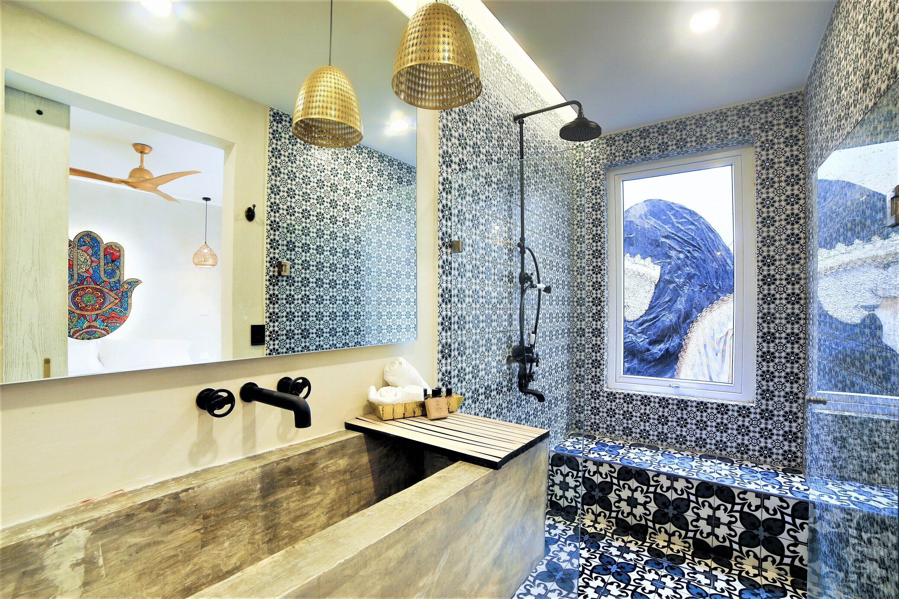A bathroom with a wooden vanity, a large mirror, and a shower area.