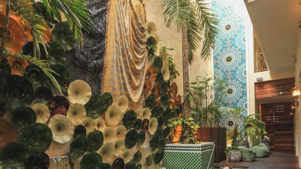 A pool area with a wooden deck, surrounded by tropical plants and decorative wall elements. - Layla Tulum - Adults Only (Tulum)