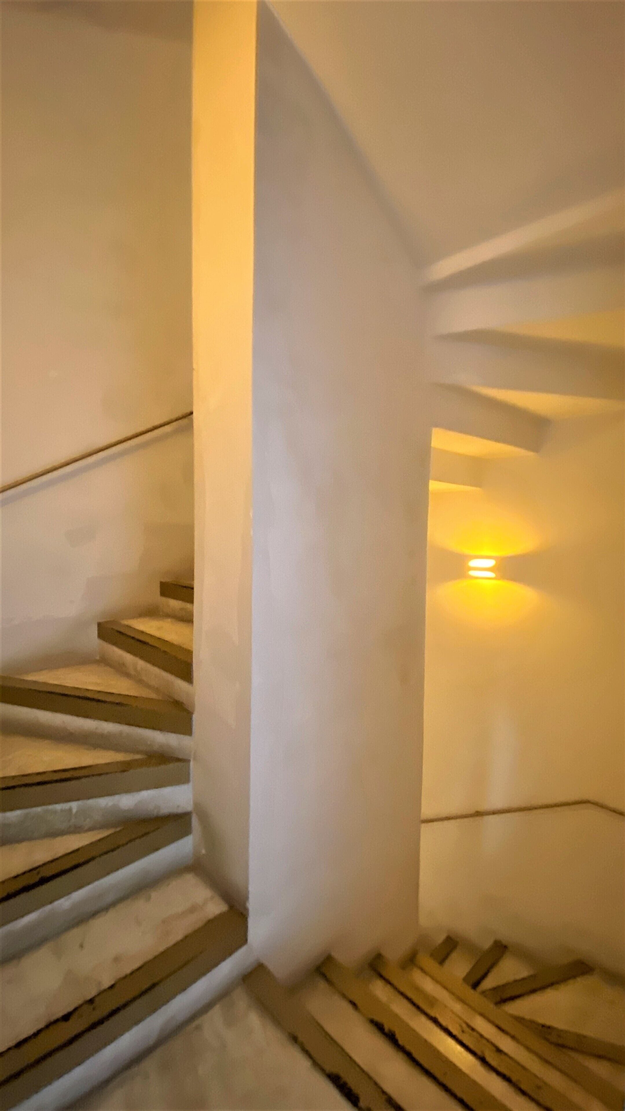Un escalier avec des marches en bois et des murs blancs.