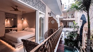 A hotel room with a bed, a ceiling fan, and a view of a pool area. - Layla Tulum - Adults Only (Tulum)