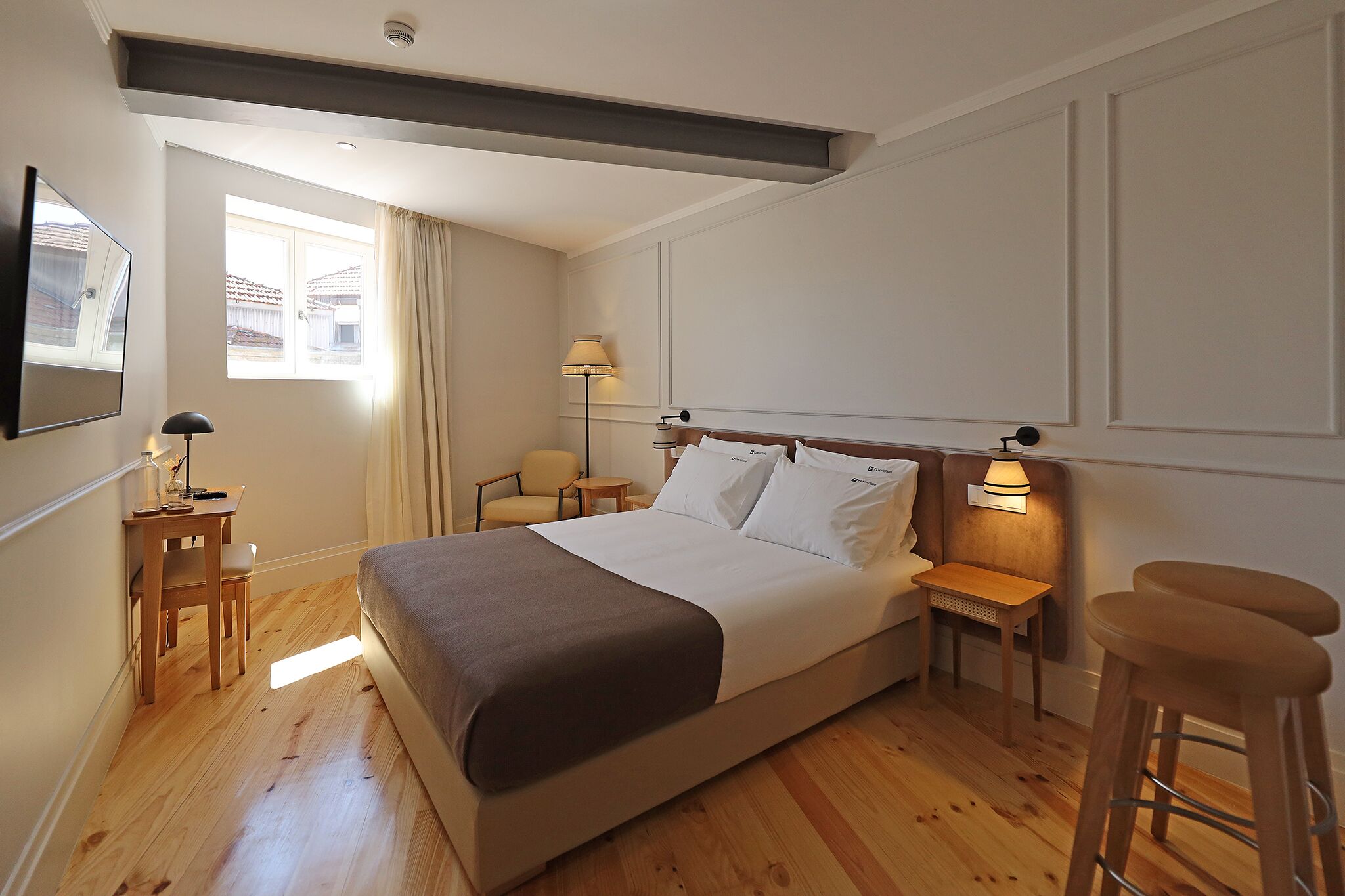 Una camera da letto con un letto, due comodini, una scrivania e una sedia.