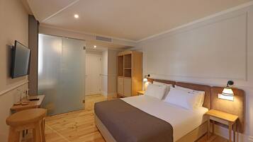 A hotel room with a bed, a TV, a desk, and a wardrobe.