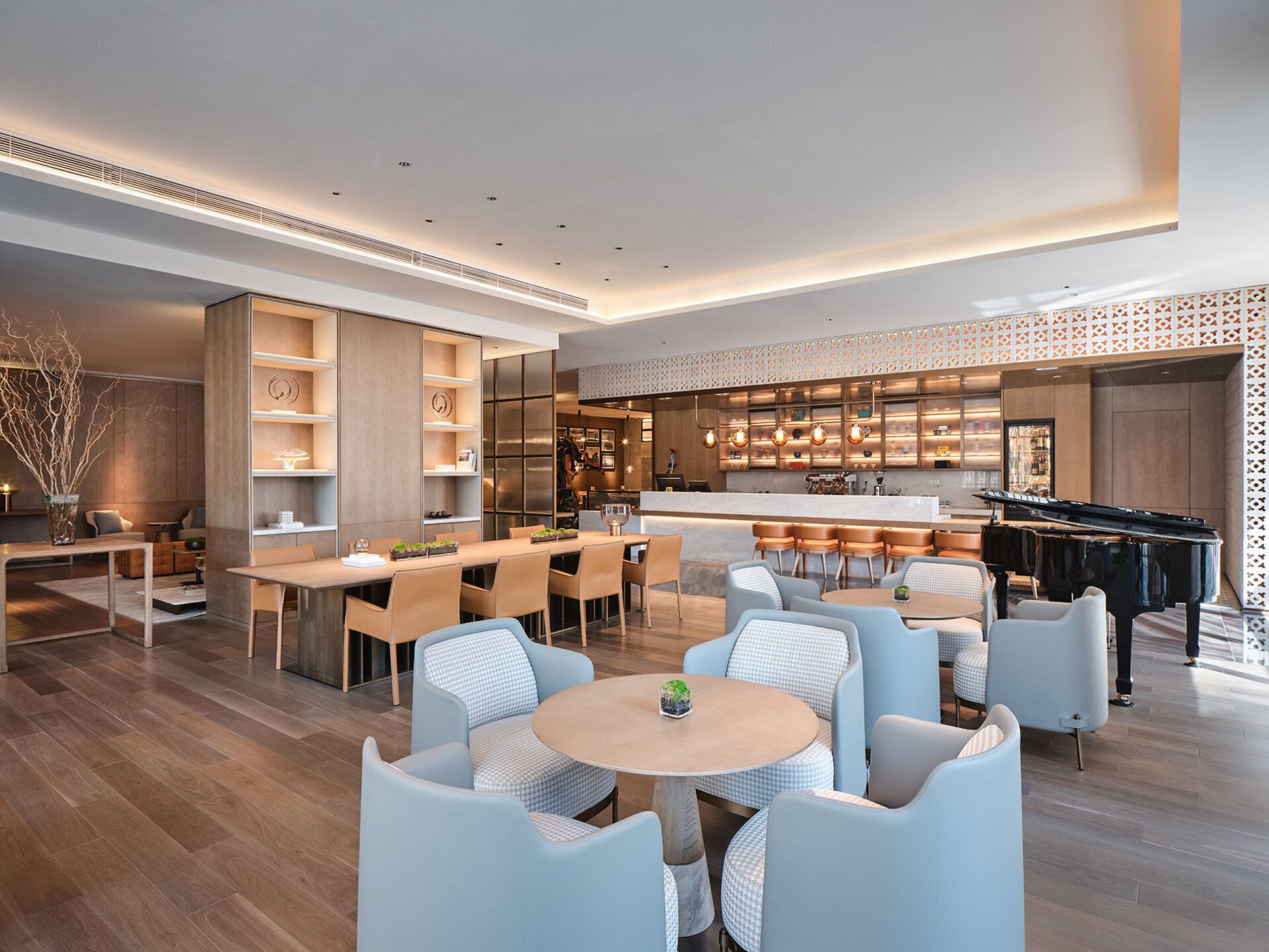 A modern hotel lobby with a bar, seating area, and a piano.