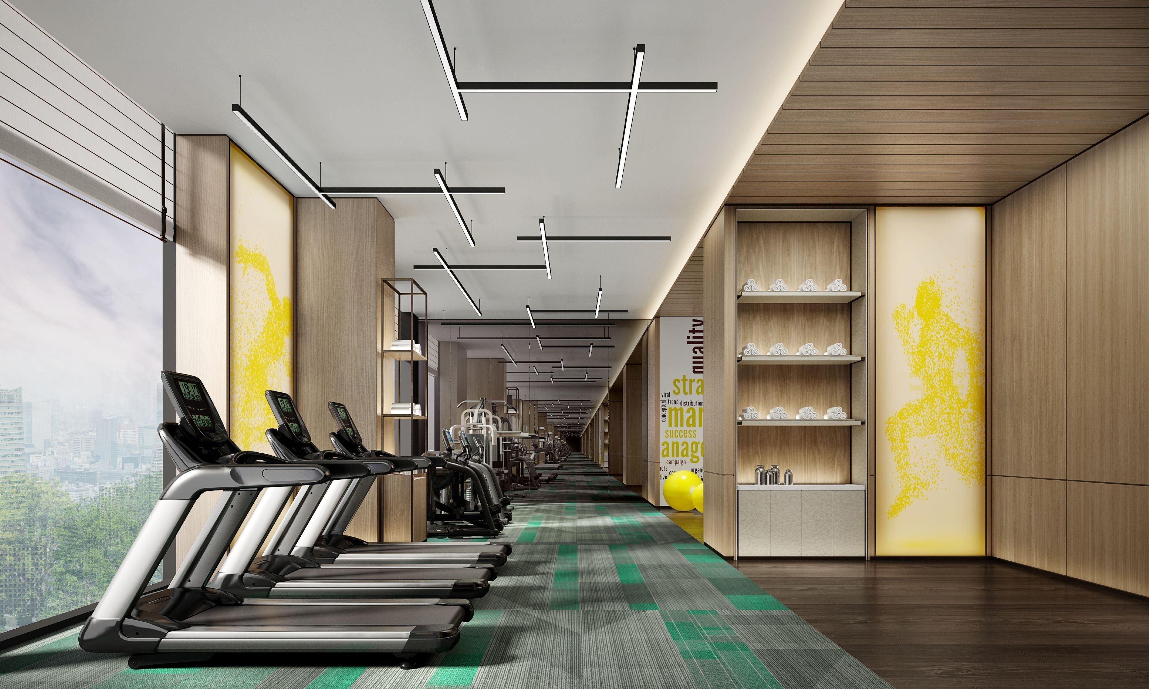 A modern gym with treadmills, exercise equipment, and a city view.
