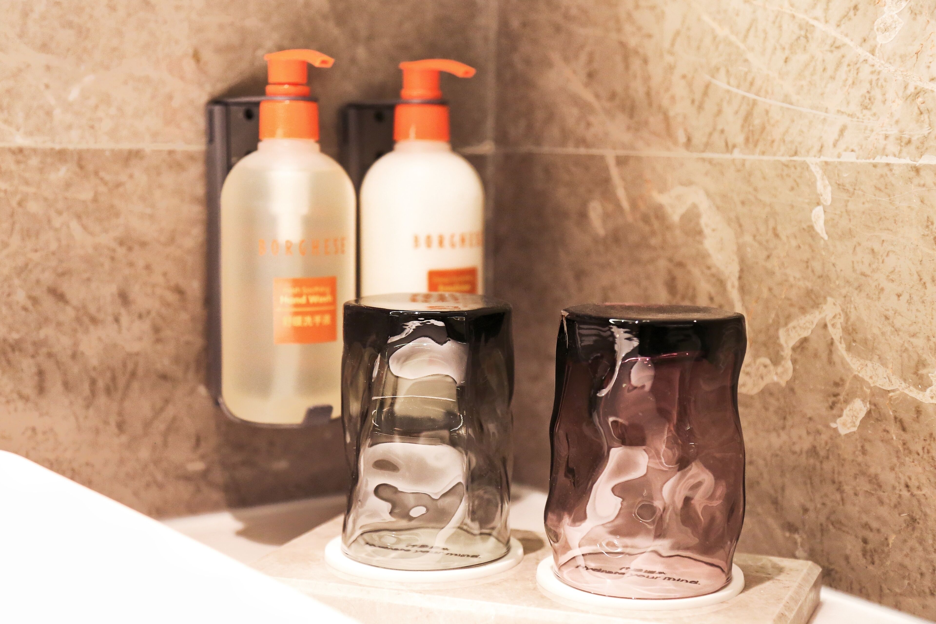 Three bottles of skincare products on a bathroom counter.