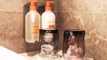 Three bottles of skincare products on a bathroom counter.