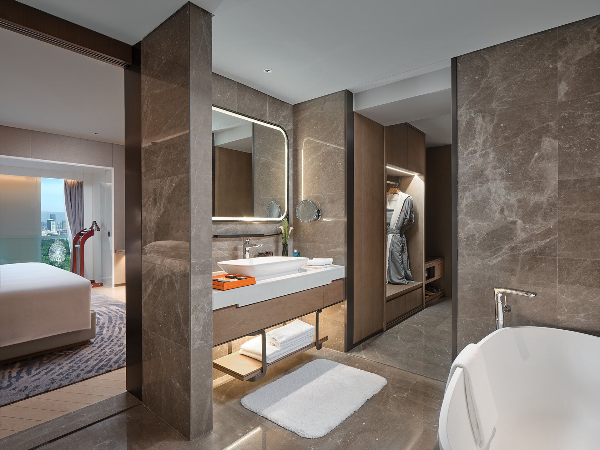 A modern bathroom with a large mirror, a white bathtub, and a vanity with a sink.