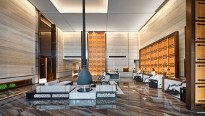 A modern lobby with a central seating area, a high ceiling with recessed lighting, and a large wooden storage unit on the right. - Crowne Plaza Hohhot City Center by IHG (Hohhot)