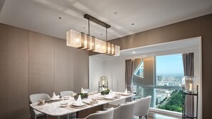 A modern dining room with a long table set for six, a city view, and a contemporary chandelier. - Crowne Plaza Hohhot City Center by IHG (Hohhot)