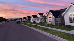 A row of single-family homes with a street in front, under a colorful sunset sky. - Bozeman Southside Retreat- 30+ Night Rental Home on Bozeman's South Side (Bozeman)
