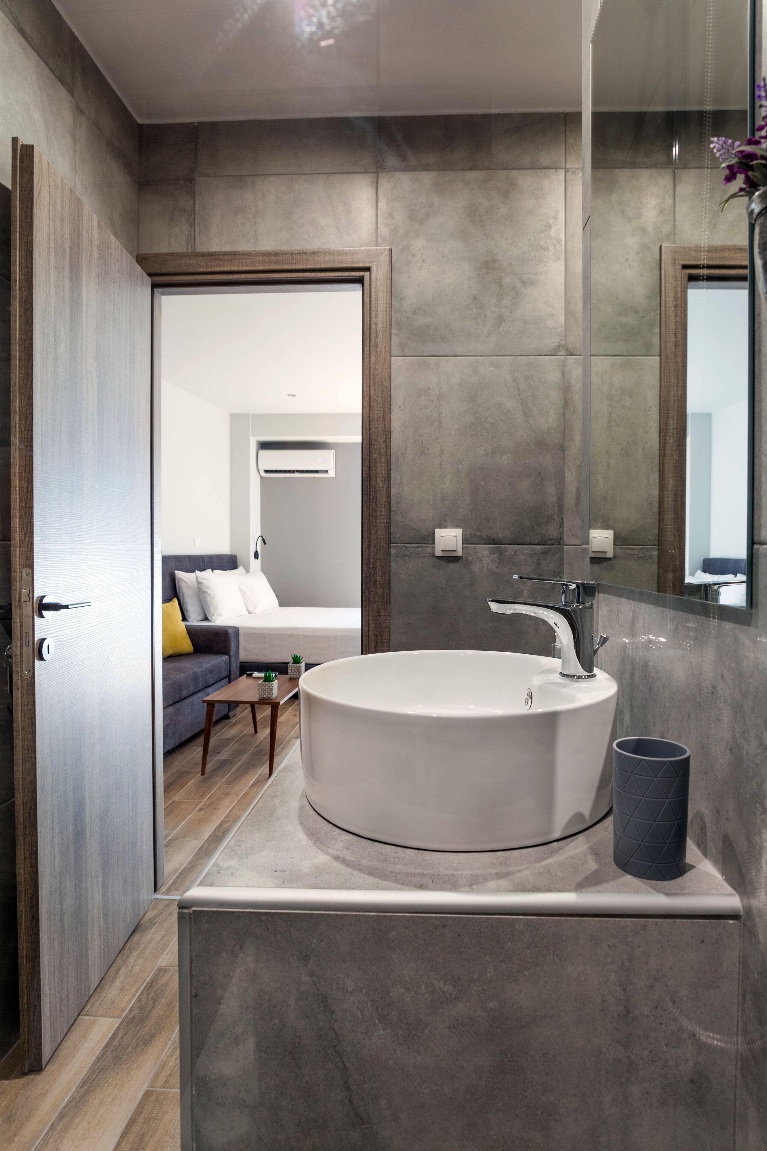 Ett modernt badrum med ett stort handfat, en spegel och ett trägolv.