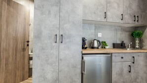 Una cocina moderna con armarios grises, un refrigerador de acero inoxidable y una encimera de madera.