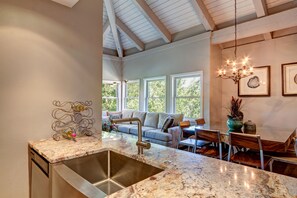 A kitchen with a granite countertop, stainless steel sink, and a dining area with a table and chairs. - Longbranch Evergreen Condo: Nice Location, Updates (Breckenridge)
